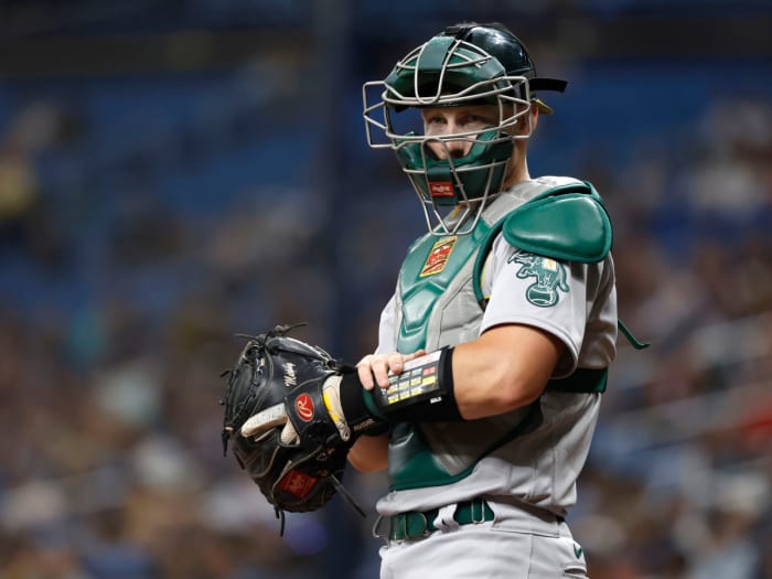 Apr 11, 2022; St. Petersburg, Florida, USA; Oakland Athletics catcher Sean Murphy (12) presses a button on his wristband and it sends a signal to a receiver in the pitcher’s hat, which then speaks to the pitcher and tells them what pitch to throw, during the first inning at Tropicana Field.